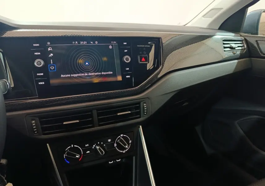 Vue intérieure côté passager du tableau de bord noir avec écran tactile 8 pouces et commandes climatisation de la Volkswagen Polo.