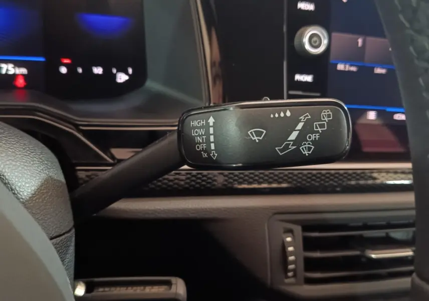 Gros plan sur la commande d’essuie-glace à gauche du volant dans l’habitacle d’une Volkswagen Polo gris foncé 2025.
