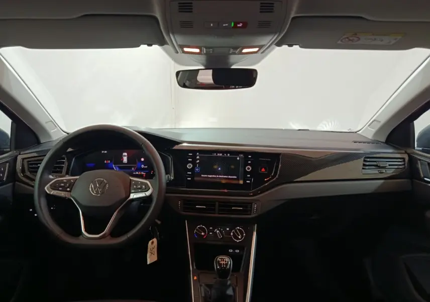 Vue intérieure avant du tableau de bord de la Volkswagen Polo gris foncé avec écran tactile et volant multifonctions.