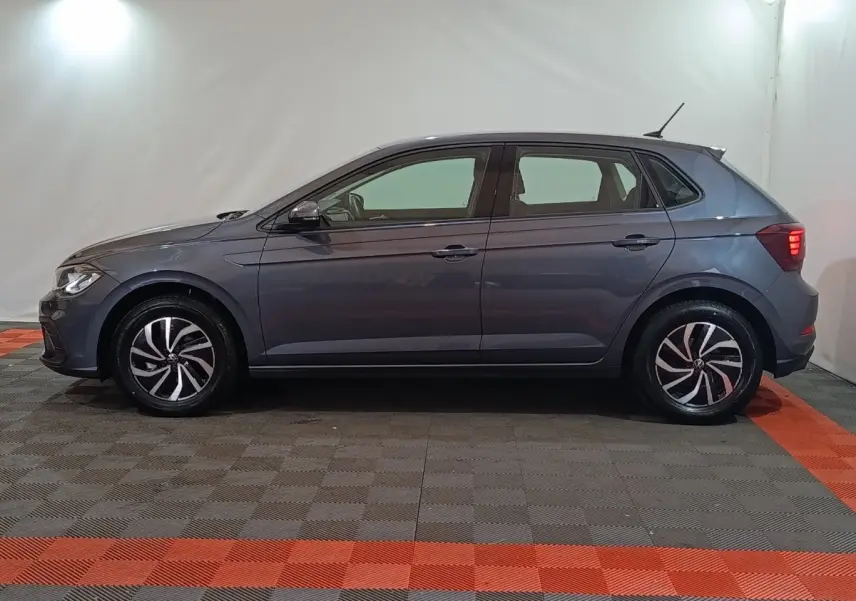Vue latérale droite d'une Volkswagen Polo gris foncé 2025 avec jantes alliage et feux arrière allumés.