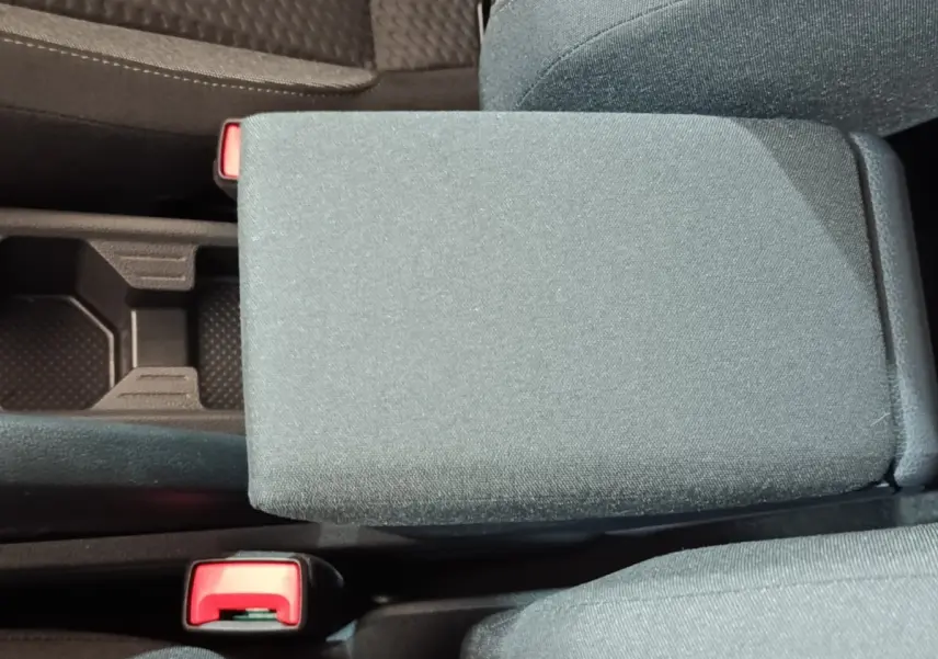 Vue rapprochée de l'accoudoir central en tissu gris foncé entre les sièges avant d'une Volkswagen Polo 2025.