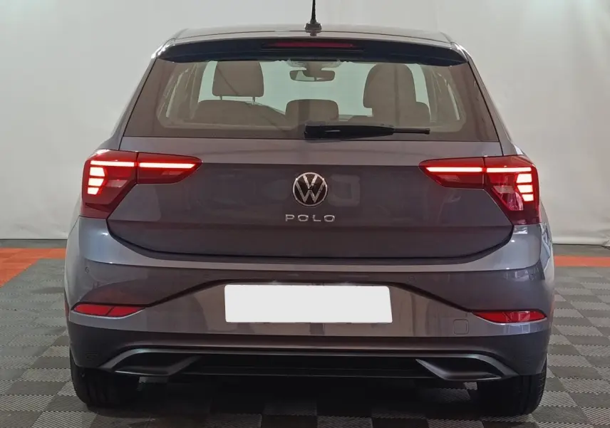 Vue arrière d'une Volkswagen Polo gris foncé 2025 avec feux arrière LED allumés dans un intérieur neutre.