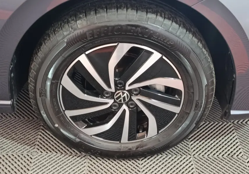 Gros plan sur la roue avant droite d'une Volkswagen Polo gris foncé avec jante alliage bicolore.