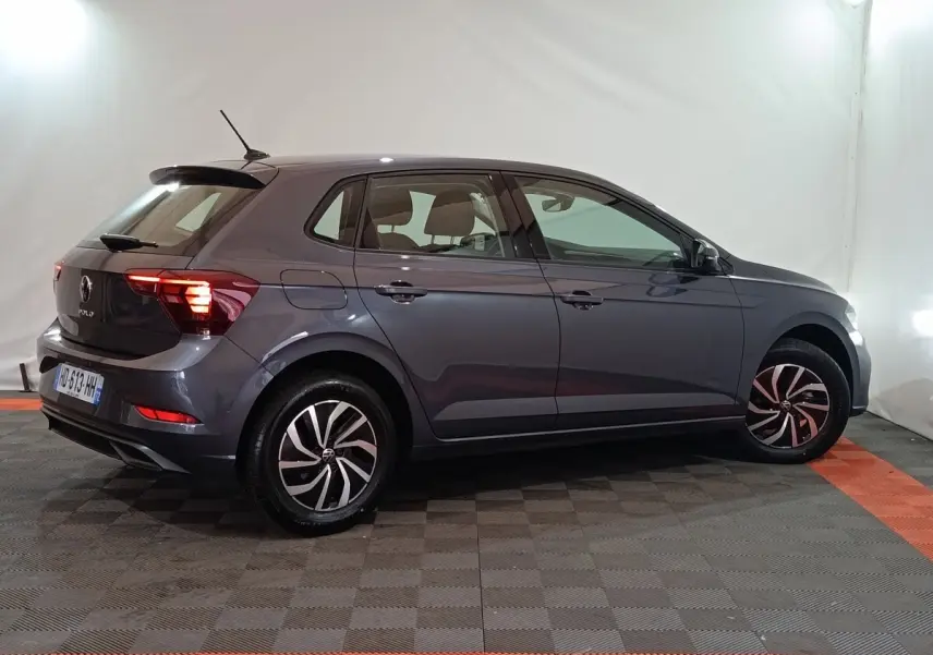 Volkswagen Polo gris foncé vue de profil côté droit, avec feux arrière LED allumés dans un studio.