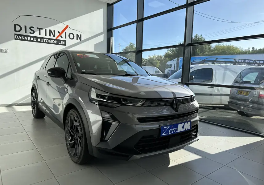 Renault SYMBIOZ gris Cassiopée en 3/4 avant droit dans un showroom avec jantes noires et calandre marquée.
