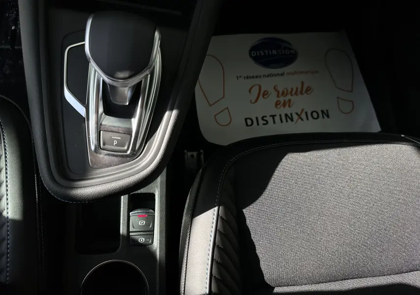 Gros plan sur la console centrale et le levier de vitesses automatique du Renault Symbioz gris, avec siège en tissu noir.