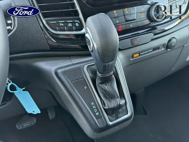 Gros plan sur le levier de vitesse automatique en cuir noir dans l'habitacle du Ford Transit Custom 2023.