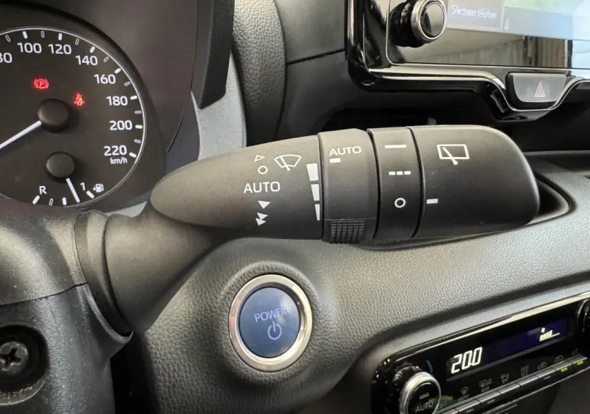 Gros plan intérieur sur la commande d’essuie-glace et le bouton Power de la Toyota Yaris hybride blanche de 2022.