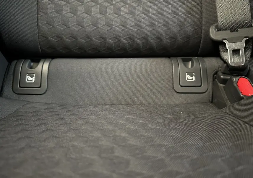 Détail de la banquette arrière noire de la Toyota Yaris hybride 2022 avec fixation Isofix et ceinture de sécurité visible.