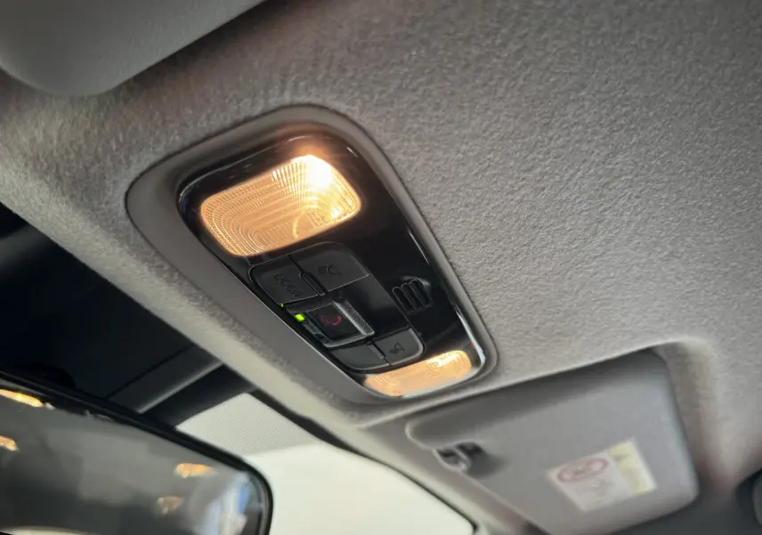 Plafonnier intérieur allumé avec commandes SOS et éclairages, vue du toit de la Toyota Yaris hybride blanche 2022.