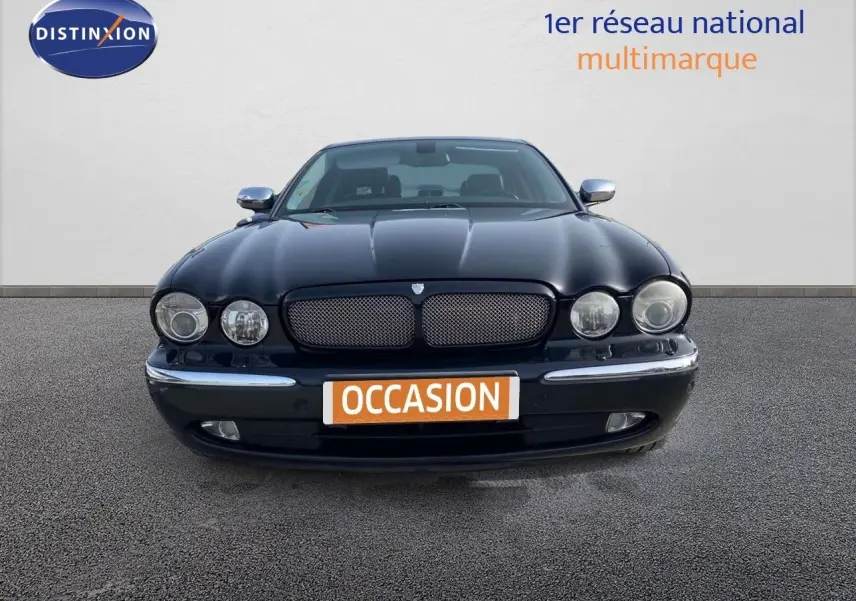 Vue frontale d'une Jaguar XJ6 noire de 2006 avec calandre distinctive et phares ronds doubles.