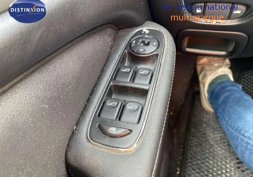 Gros plan sur les commandes des vitres électriques côté gauche d'une Jaguar XJ6 noire de 2006, intérieur cuir noir.