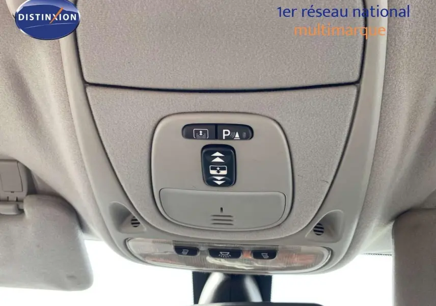 Vue intérieure en gros plan du plafonnier gris avec commandes d’éclairage et capteur de stationnement d’une Jaguar XJ6 noire.