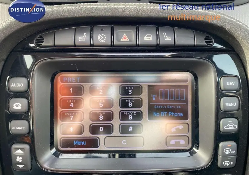 Gros plan sur l’écran central tactile et les commandes de la Jaguar XJ6 noire de 2006, intérieur élégant et fonctionnel.