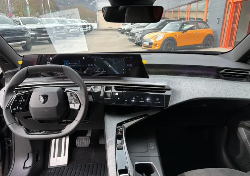 Vue intérieure avant du Peugeot 3008 Hybrid 145 GT Alcantara, tableau de bord moderne avec volant cuir et écran large.