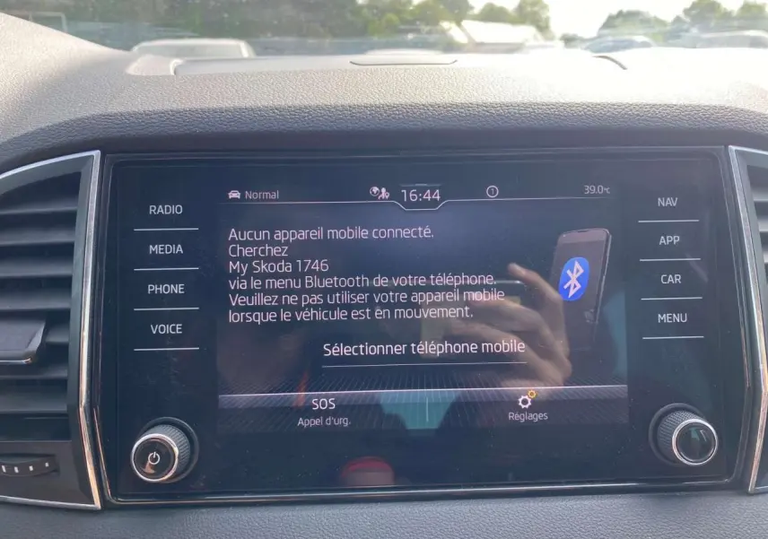 Vue rapprochée de l'écran tactile central du Skoda Karoq vert foncé, affichant le menu Bluetooth et les commandes multimédia.