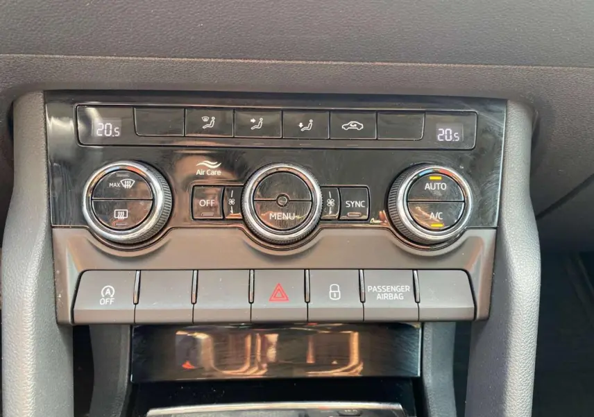 Gros plan sur la console centrale du Skoda Karoq vert foncé 2021, montrant les commandes de climatisation et les boutons de fonction.