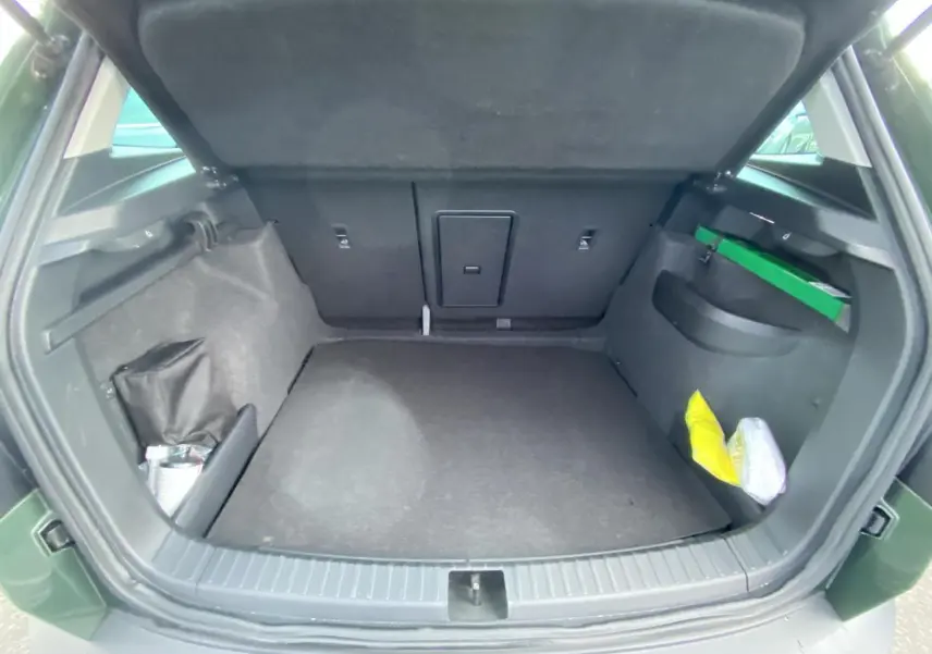 Coffre ouvert vu de l'arrière d'un Skoda Karoq Scout 2021 vert foncé, montrant un espace de chargement vide.
