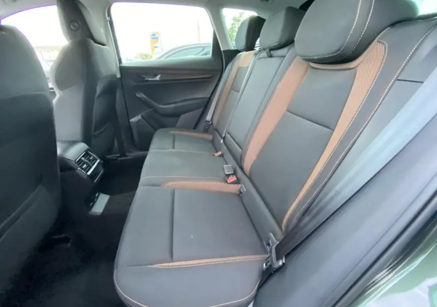 Vue intérieure côté droit des sièges arrière en cuir noir avec surpiqûres orange du Skoda Karoq Scout vert foncé 2021.