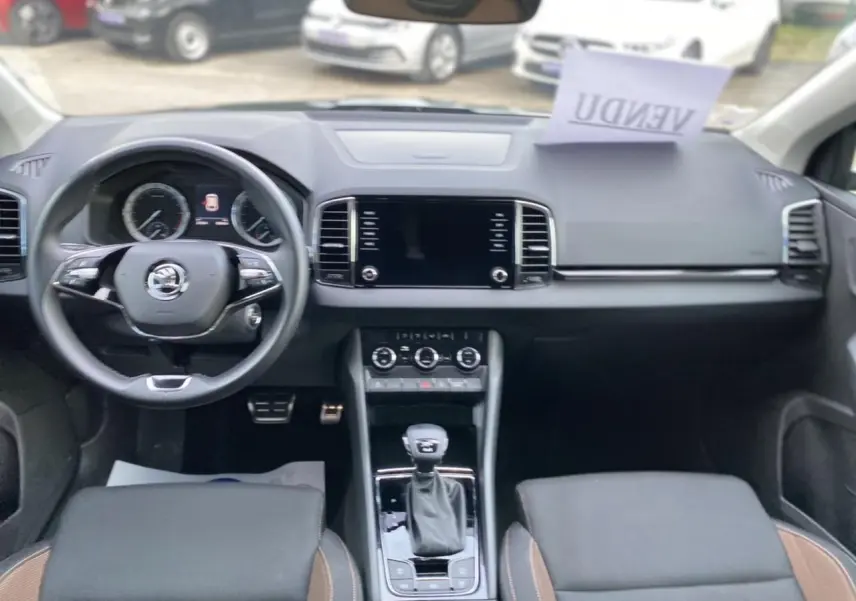 Vue intérieure frontale du tableau de bord et volant du Skoda Karoq 2021, finition Scout, avec console centrale et écran tactile.