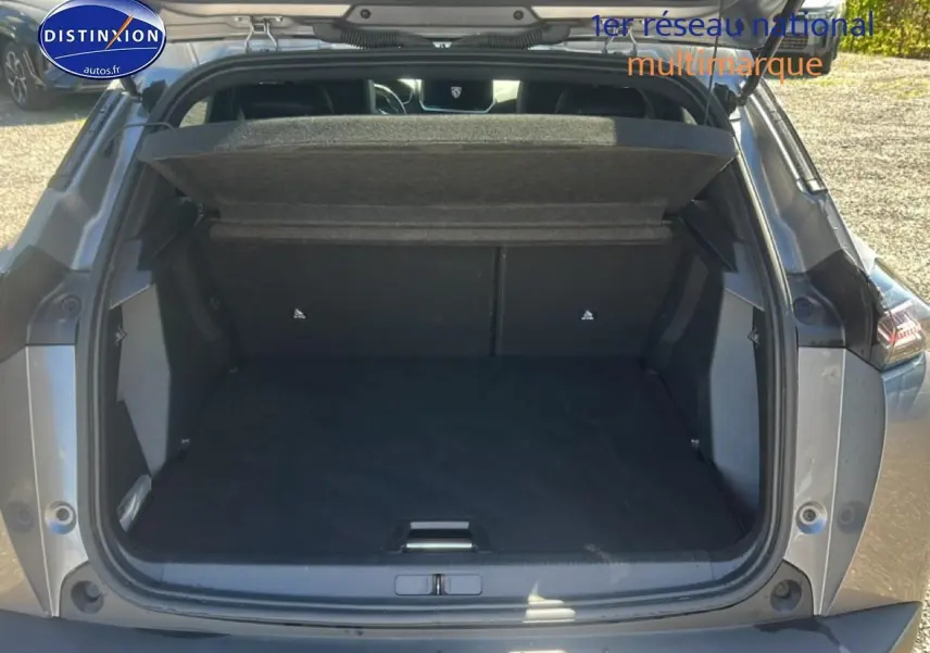 Coffre ouvert vu de l'arrière d'un Peugeot 2008 gris artense, montrant l'espace de chargement vide.
