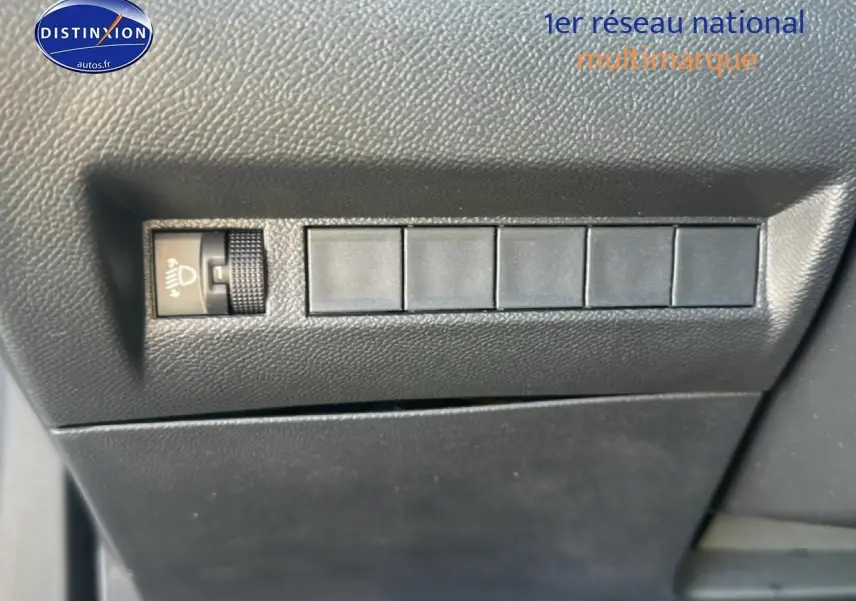 Détail intérieur montrant les commandes de réglage des phares sur la Peugeot 2008 gris artense, version 2025.
