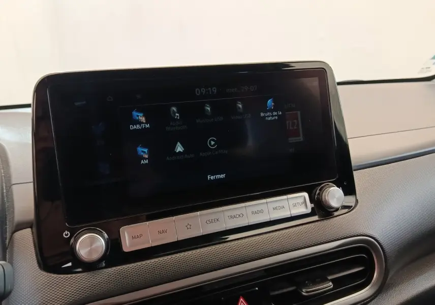 Écran tactile central noir affichant les options multimédias dans l’habitacle d’une Hyundai Kona électrique 2023.