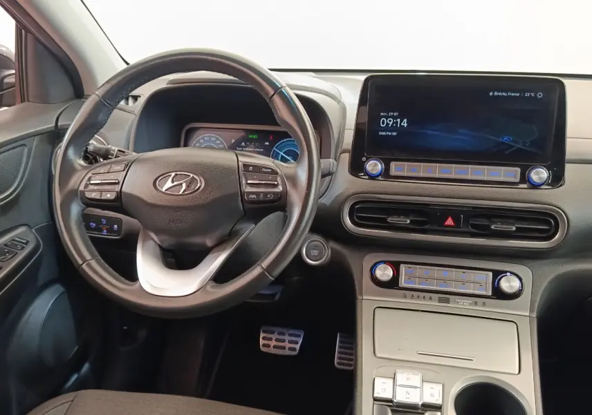 Vue intérieure avant du tableau de bord et volant cuir de la Hyundai KONA électrique 2023 avec écran tactile central.