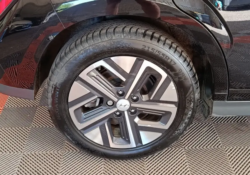 Gros plan sur la roue arrière droite du Hyundai Kona électrique noir 2023 avec jante alliage distinctive.