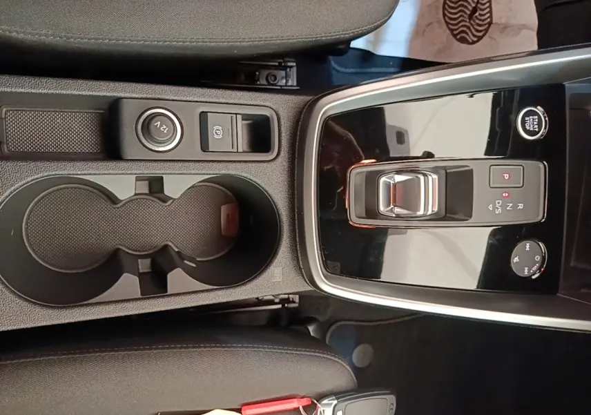 Vue plongeante sur la console centrale noire de l'Audi A3 40 TFSI e avec sélecteur de vitesse et porte-gobelets.