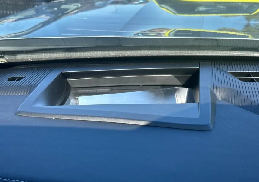 Détail du tableau de bord noir du Jeep Compass 2026 montrant l'écran escamotable sous le pare-brise.