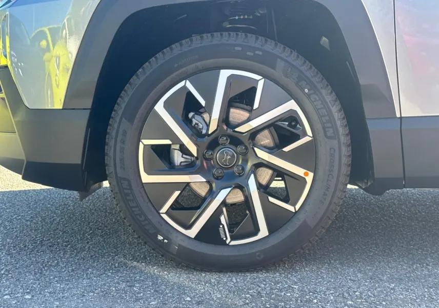 Gros plan sur la roue avant gauche du Jeep Compass 2026 Yosemite avec jante alu bicolore et logo Jeep central.