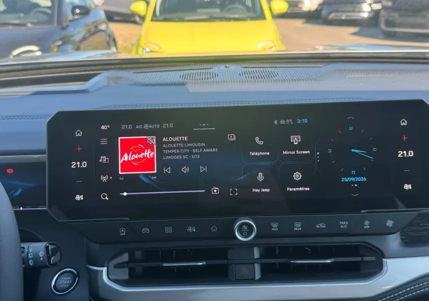Vue intérieure du tableau de bord du Jeep Compass 2026 avec écran tactile large affichant la radio et la climatisation.