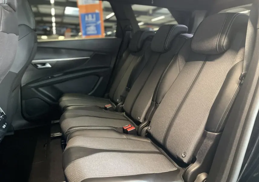 Vue latérale droite des trois sièges arrière indépendants en tissu et cuir noir du Peugeot 5008 2024 finition Allure Pack.
