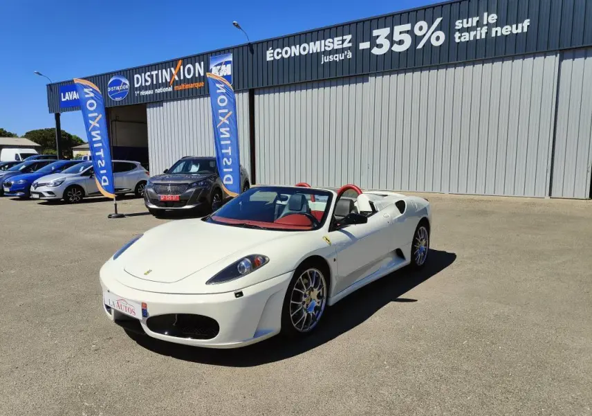 Ferrari F430 Spider blanc 60ème anniversaire vue 3/4 avant avec intérieur rouge et capote ouverte.