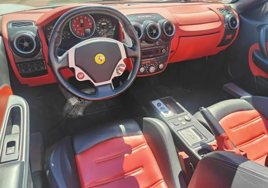 Intérieur de Ferrari F430 Spider 60ème Anniversaire 2007, vue côté conducteur, cuir rouge et noir avec tableau de bord orange.