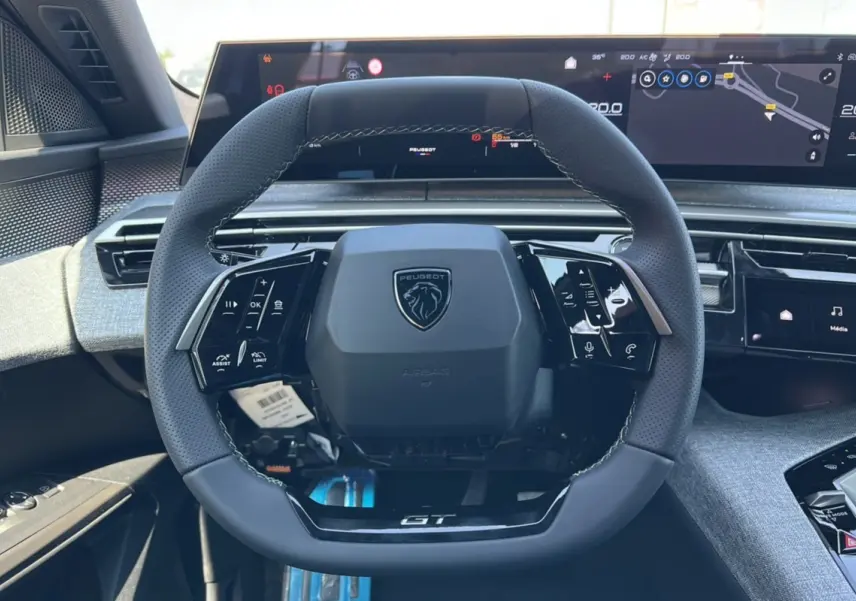 Vue rapprochée du volant GT en Alcantara du Peugeot 3008 Hybrid 145, avec tableau de bord numérique moderne.