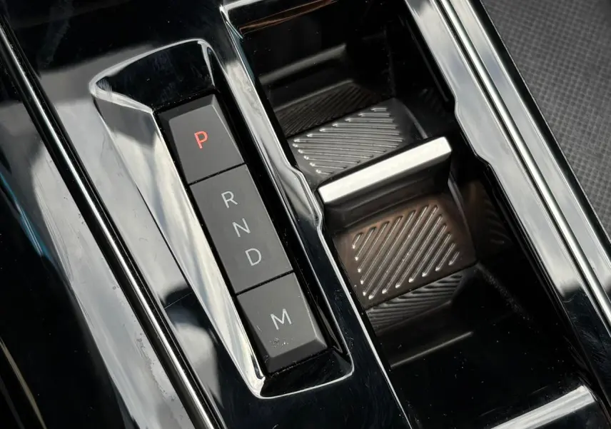 Gros plan sur la commande de boîte automatique noire brillante du Peugeot 3008 2023, avec boutons P, R, N, D, M.
