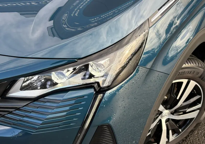 Gros plan sur l'avant droit du Peugeot 3008 bleu Célèbes, mettant en valeur le phare LED et la jante alliage 18 pouces.