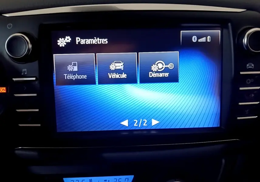 Écran tactile central de la Toyota Yaris 1.5 VVT-I HYBRID blanc, affichant le menu Paramètres en intérieur.
