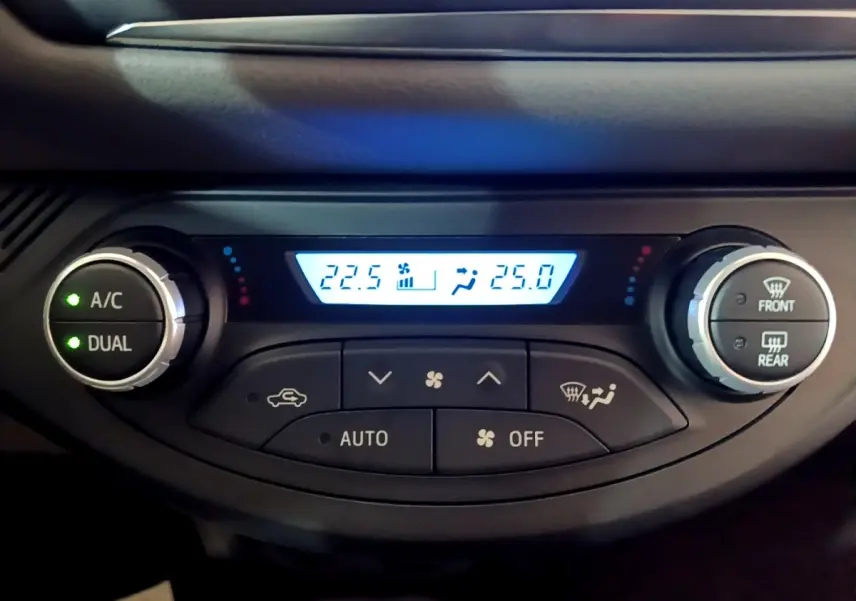 Détail de la console de climatisation digitale bi-zone de la Toyota Yaris blanche, affichage des températures à 22,5°C et 25°C.