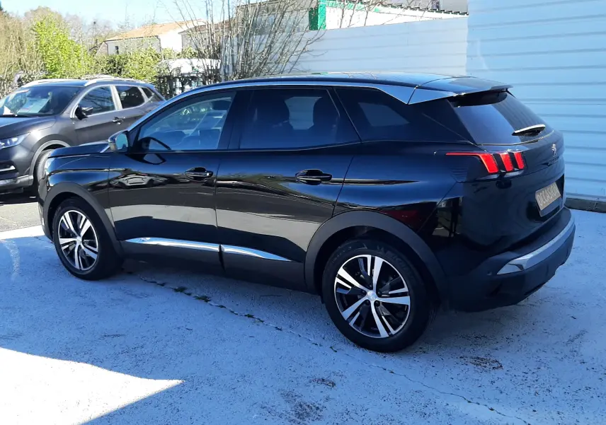 Peugeot 3008 noir vue 3/4 arrière droit, avec feux arrière à effet griffes et jantes alliage bicolores.