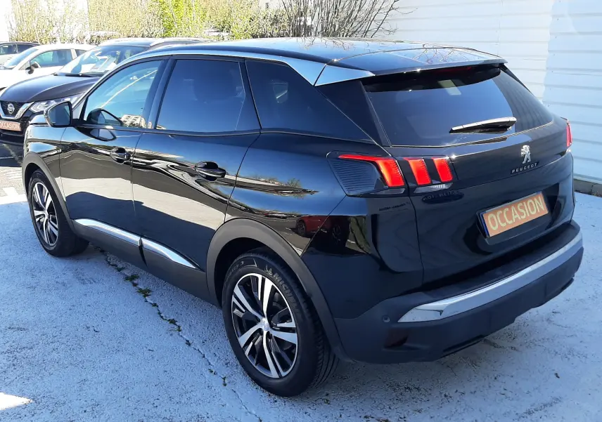 Peugeot 3008 noir en 3/4 arrière droit, avec feux arrière à trois griffes et jantes alliage bicolores.