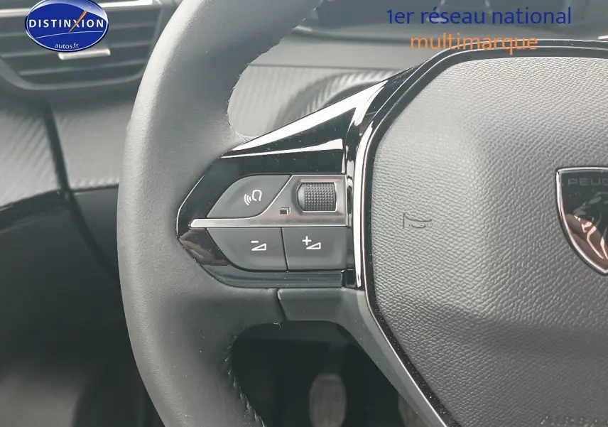 Gros plan sur le volant multifonction noir du Peugeot 2008 1.2 100 allure avec commandes audio intégrées.