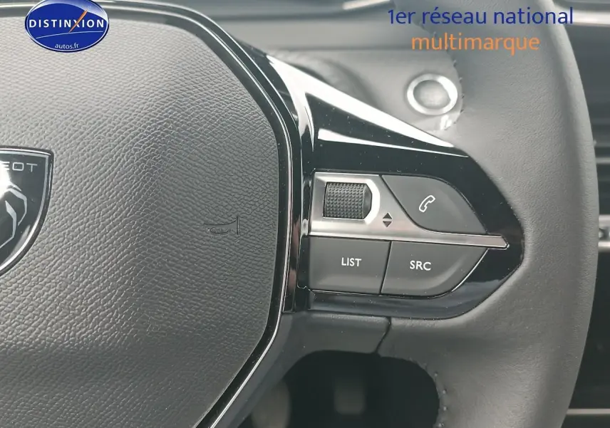 Gros plan sur le volant multifonction noir de la Peugeot 2008 1.2 100 allure, avec commandes audio et téléphone.
