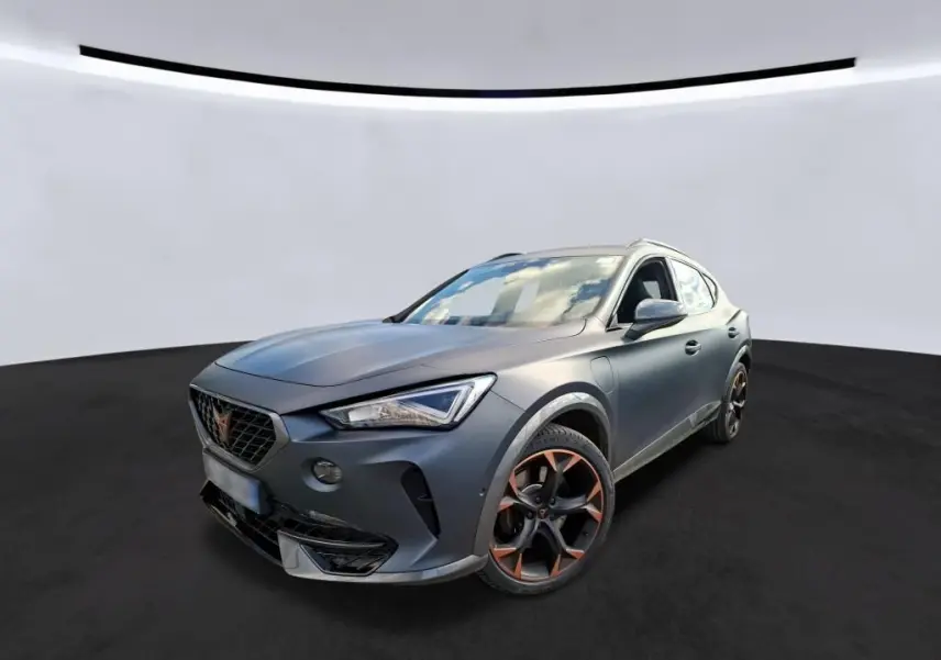 Vue 3/4 avant d’un CUPRA Formentor 1.4 E-HYBRID 245 DSG6 VZ gris foncé mat avec jantes noires et accents cuivrés.