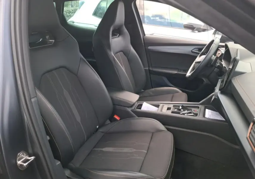 Vue intérieure côté conducteur de la CUPRA Formentor 1.4 E-HYBRID 245 DSG6 VZ 2024 avec sièges sport noirs et console centrale.