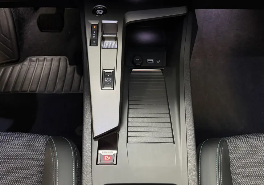 Vue plongeante sur la console centrale de la Peugeot 308 Hybrid 145, avec levier de vitesses et bouton start/stop.