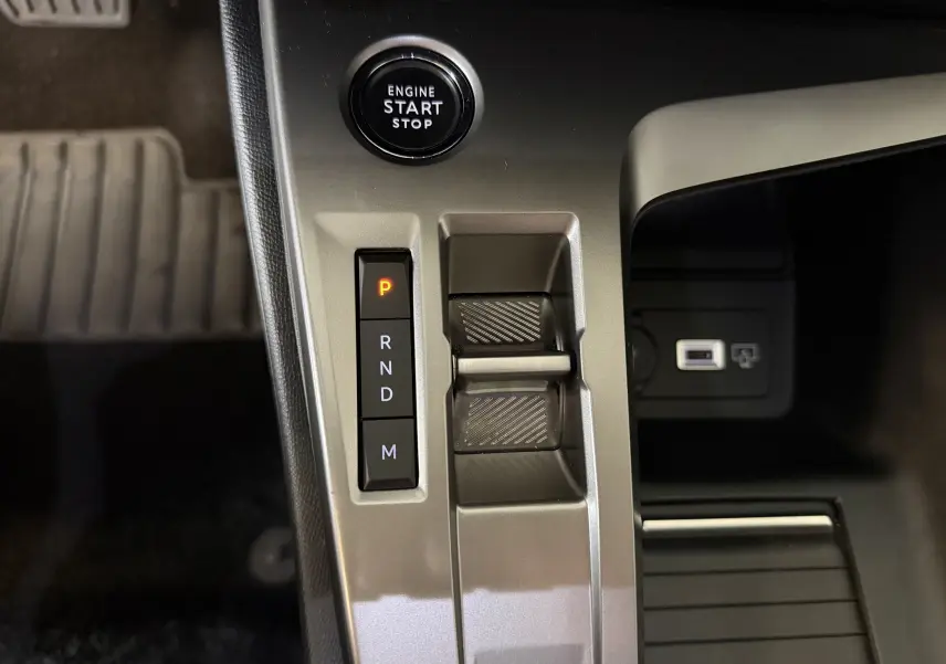 Gros plan sur la console centrale de la Peugeot 308 Hybrid 145 e-DCS6 Allure, montrant le bouton start/stop et la commande de boîte automatique.