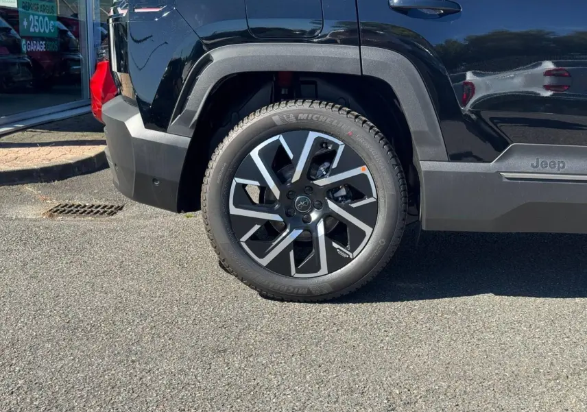 Gros plan sur la roue arrière gauche du Jeep Compass Vulcano 2026 avec jante alu et logo Jeep sur la porte.